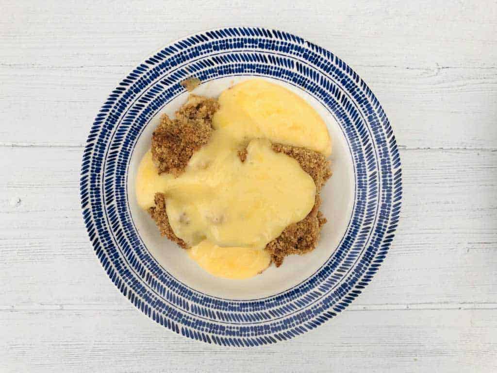 How To Make Apple Crumble apple crumble in bowl with custard